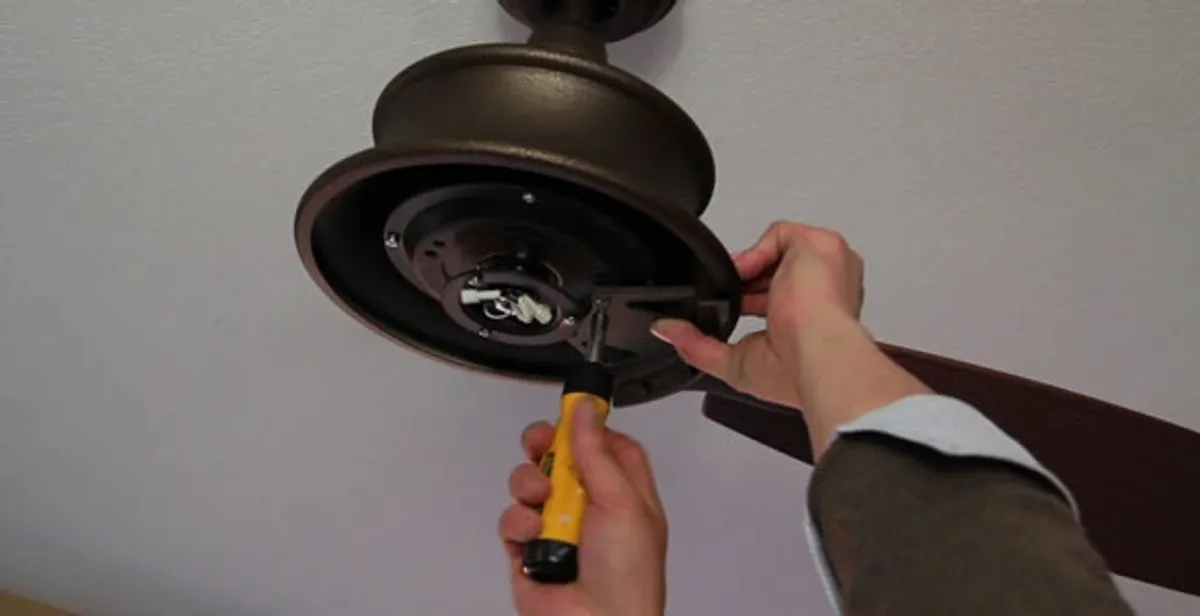 Electrician installing ceiling fan mounting bracket and fixture in Fort Wayne, IN